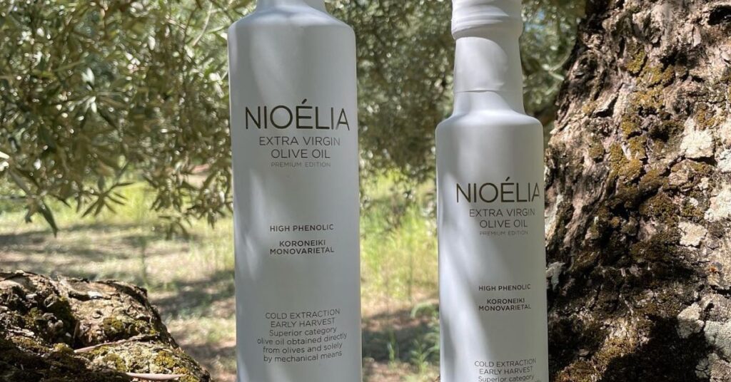 Nioelia olive oil bottles on an olive tree